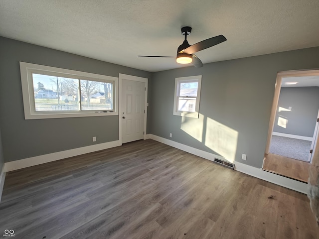 unfurnished bedroom with wood-type flooring, a textured ceiling, and ceiling fan