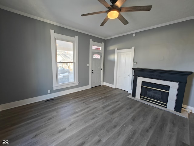 unfurnished living room with ceiling fan, dark wood-type flooring, and ornamental molding