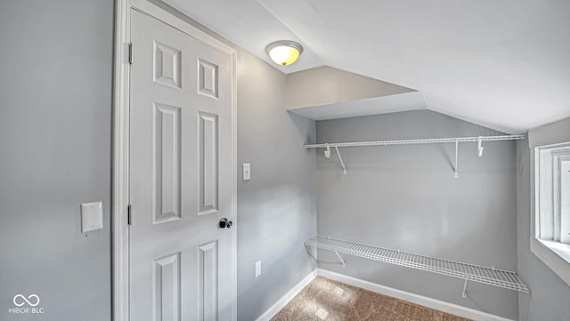 walk in closet with carpet and lofted ceiling