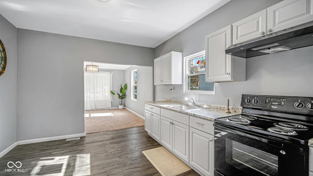 kitchen with black range with electric stovetop, a wealth of natural light, sink, and white cabinets