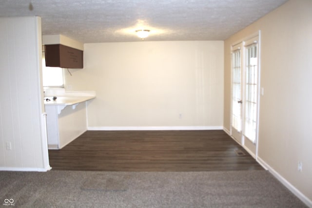 interior space featuring a textured ceiling, dark wood-type flooring, and french doors