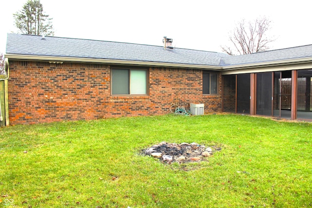 rear view of house with a sunroom and a lawn