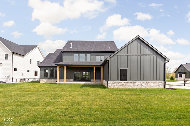 rear view of house featuring a lawn and a sunroom