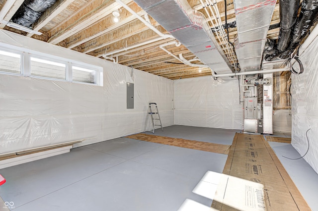 basement featuring electric panel and heating unit