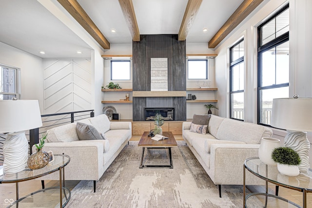 living room featuring a large fireplace, beamed ceiling, and light wood-type flooring