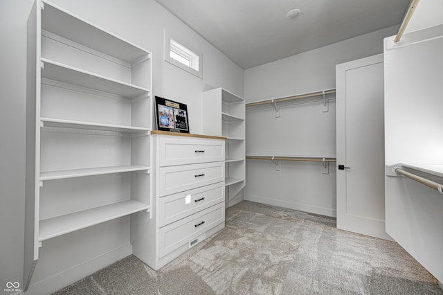 walk in closet with light colored carpet