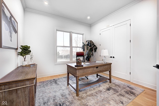 home office with light hardwood / wood-style floors and crown molding