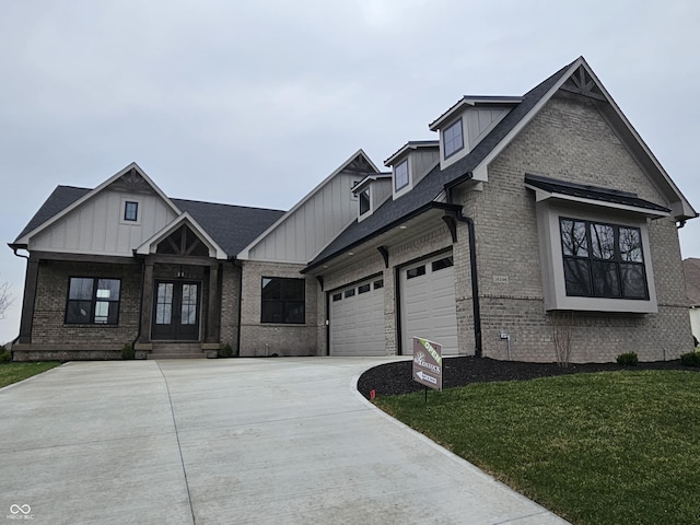 16298 Grand Cypress Dr, Noblesville, IN 46060 - view of front facade with french doors, brick siding, driveway, and board and batten siding