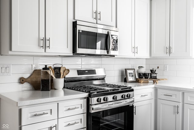 kitchen with decorative backsplash, white cabinetry, and stainless steel appliances