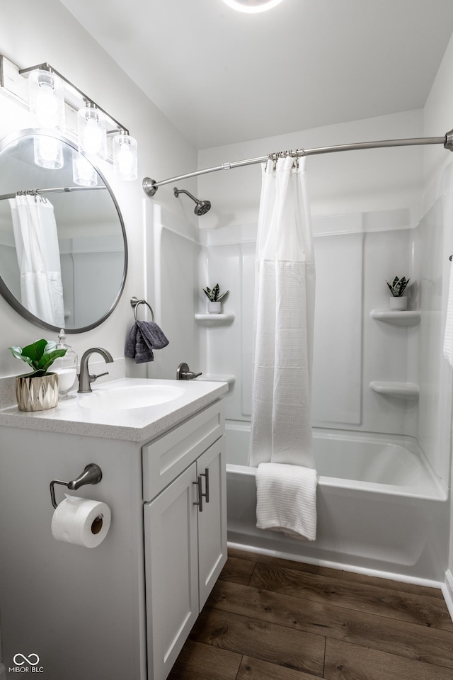 bathroom featuring wood-type flooring, vanity, and shower / tub combo with curtain