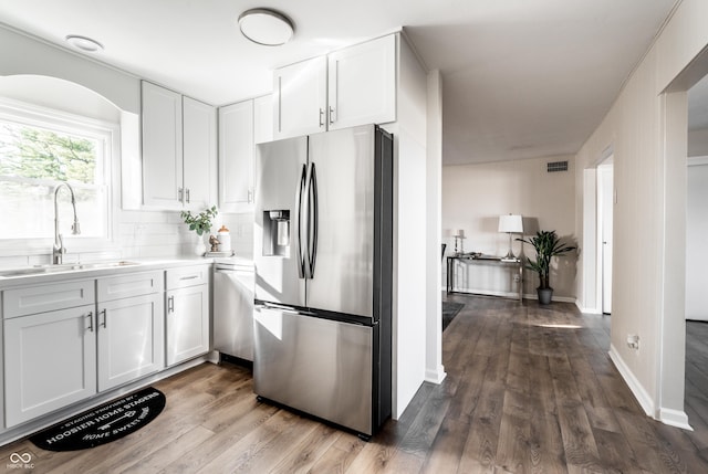 kitchen with white cabinets, stainless steel fridge with ice dispenser, dark hardwood / wood-style floors, and sink