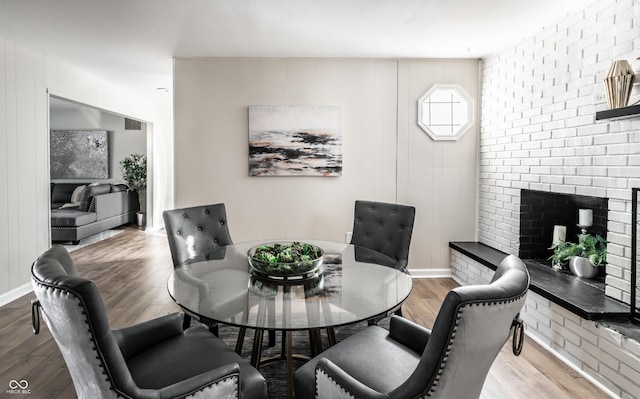 dining area with light hardwood / wood-style floors and a fireplace