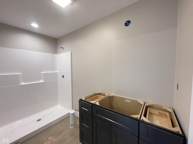 bathroom with hardwood / wood-style floors and walk in shower