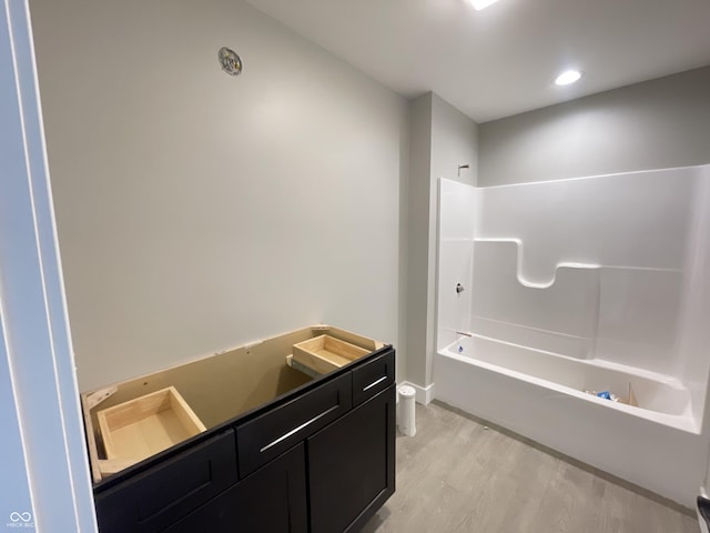 full bathroom with wood-type flooring, toilet, shower / bath combination, and vanity