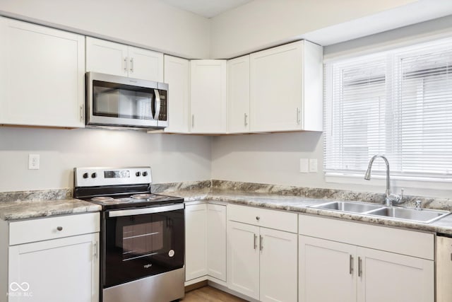 kitchen with white cabinets, sink, and appliances with stainless steel finishes