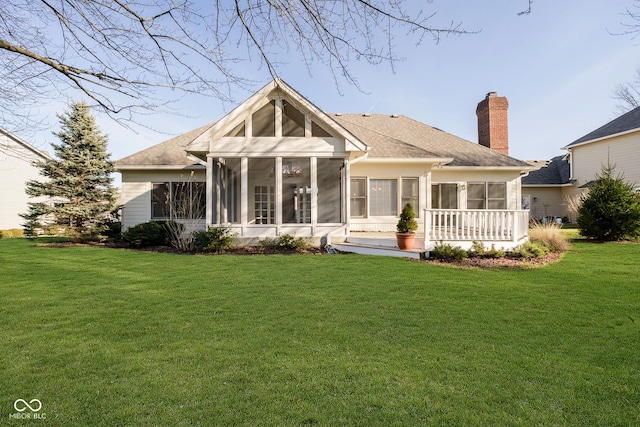 back of property with a sunroom and a lawn