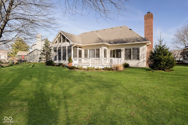 back of property featuring a lawn and a sunroom