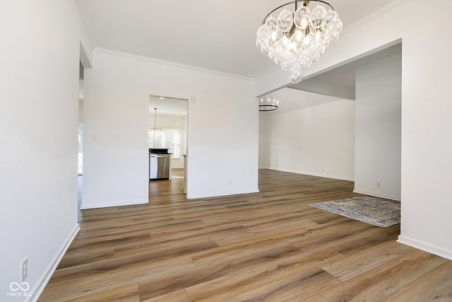 unfurnished dining area featuring an inviting chandelier, crown molding, and wood-type flooring