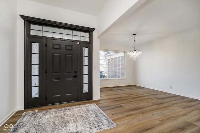 foyer entrance featuring a chandelier and wood-type flooring