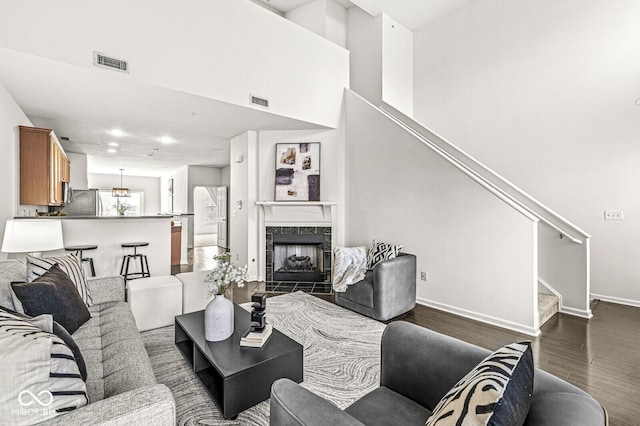 living room with dark hardwood / wood-style floors and a high end fireplace