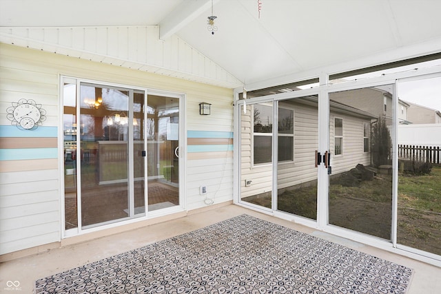 unfurnished sunroom featuring vaulted ceiling with beams