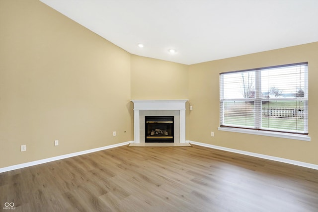 unfurnished living room with light wood-type flooring and a tile fireplace