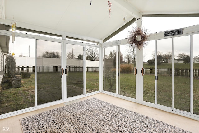 unfurnished sunroom featuring vaulted ceiling with beams