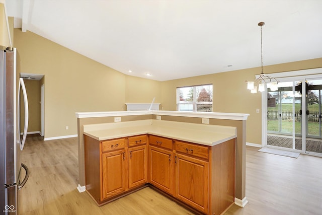 kitchen featuring vaulted ceiling, decorative light fixtures, an inviting chandelier, light hardwood / wood-style flooring, and stainless steel refrigerator