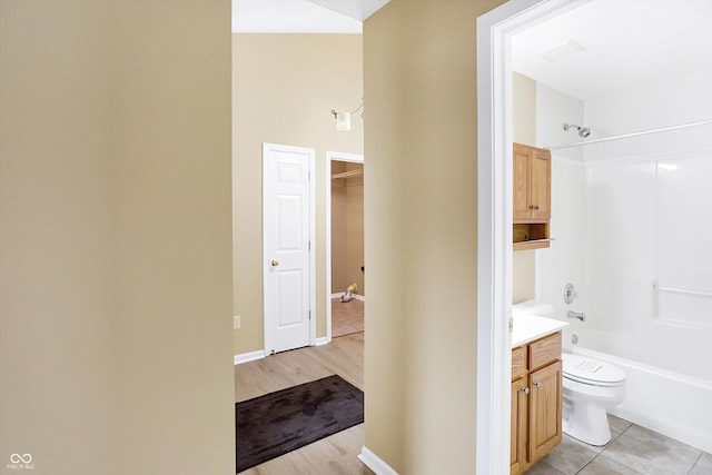 full bathroom with hardwood / wood-style flooring, vanity, toilet, and washtub / shower combination