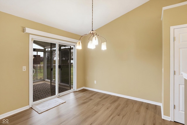 unfurnished dining area featuring hardwood / wood-style flooring and a chandelier