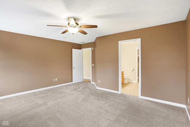 unfurnished bedroom featuring light carpet, a textured ceiling, ensuite bathroom, and ceiling fan