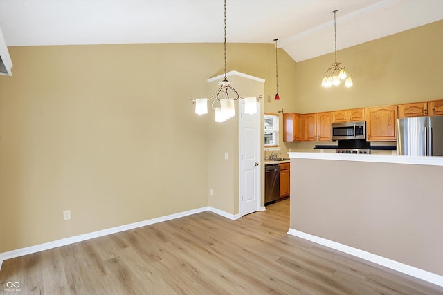 kitchen with a chandelier, pendant lighting, light wood-type flooring, and stainless steel appliances