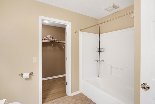 bathroom with tile patterned floors and washtub / shower combination