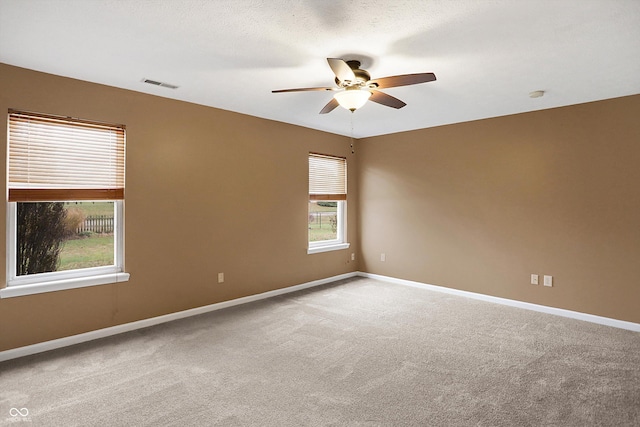 carpeted empty room with ceiling fan and a textured ceiling