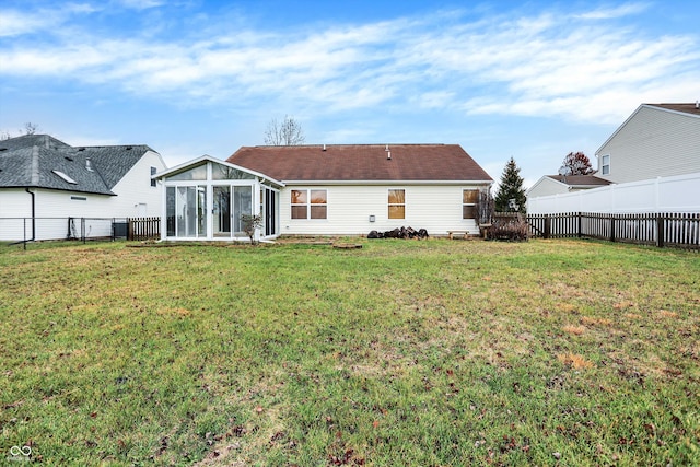 back of house with a lawn and a sunroom