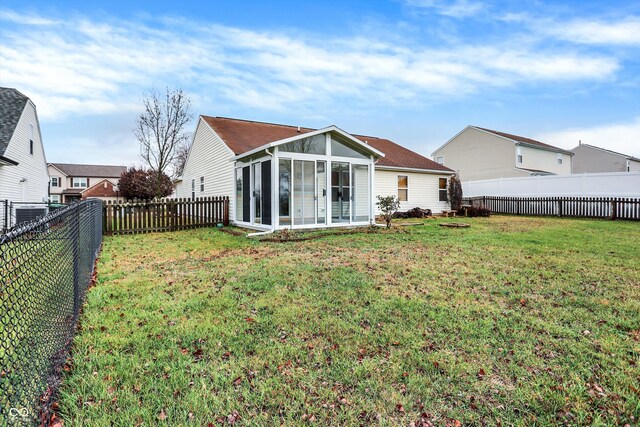 back of property featuring a sunroom and a yard