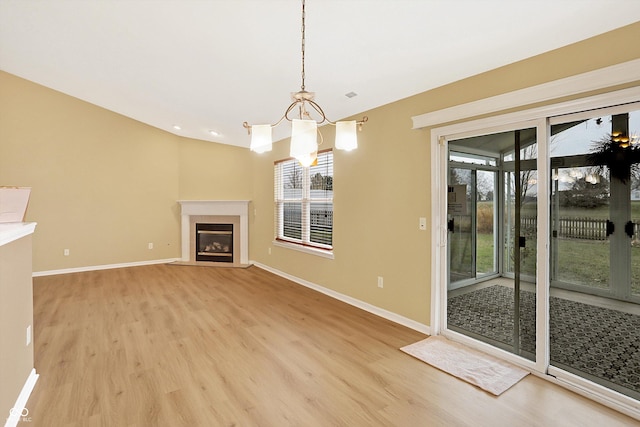 unfurnished living room featuring light wood-type flooring and a chandelier