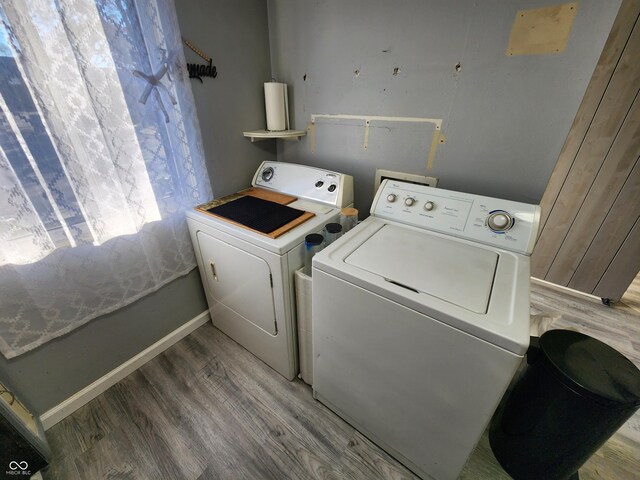 laundry area with hardwood / wood-style floors and washing machine and clothes dryer