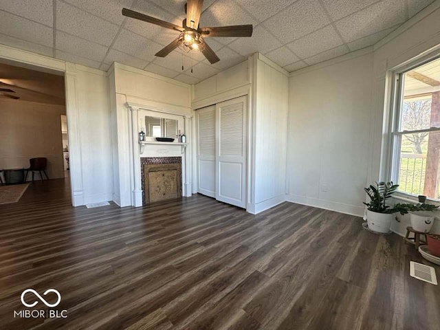 interior space featuring a paneled ceiling, ceiling fan, and dark wood-type flooring