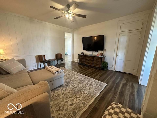 living room featuring ceiling fan and dark wood-type flooring