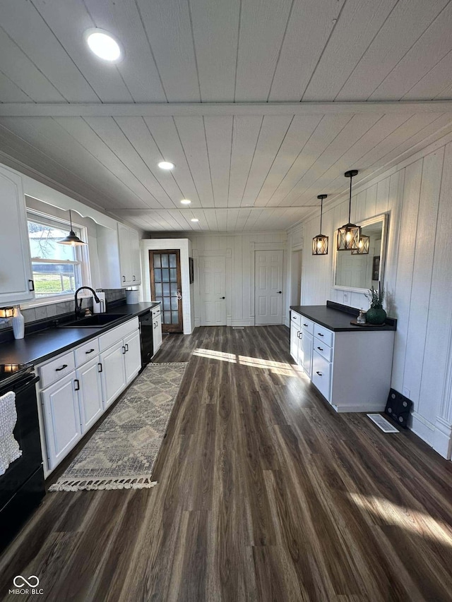 kitchen featuring sink, white cabinetry, dark wood-type flooring, and black appliances