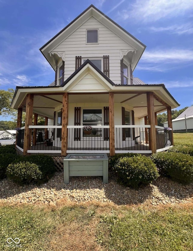 back of property featuring covered porch