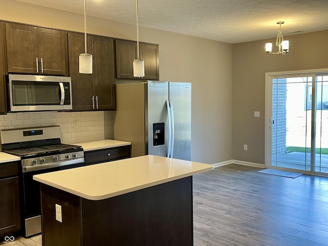 kitchen featuring dark brown cabinetry, light hardwood / wood-style floors, decorative backsplash, a kitchen island, and appliances with stainless steel finishes