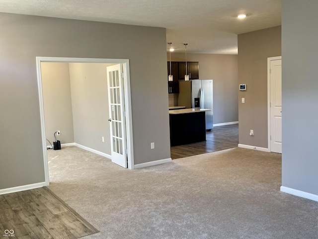 spare room featuring a textured ceiling and dark hardwood / wood-style flooring