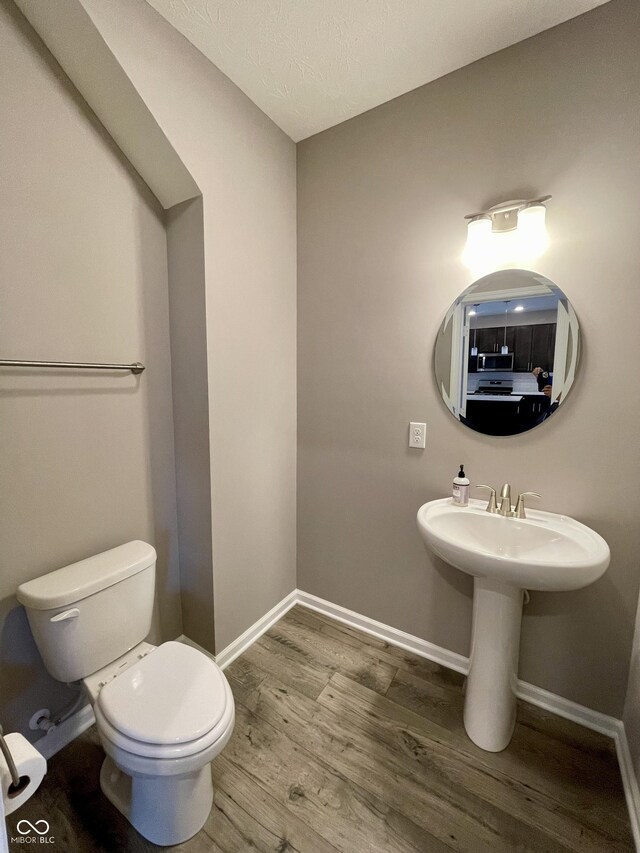 bathroom with sink, hardwood / wood-style floors, a textured ceiling, and toilet