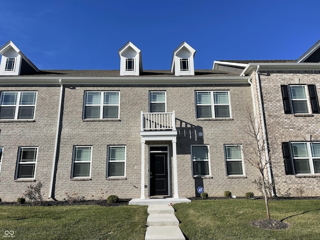 multi unit property with a front yard and a balcony