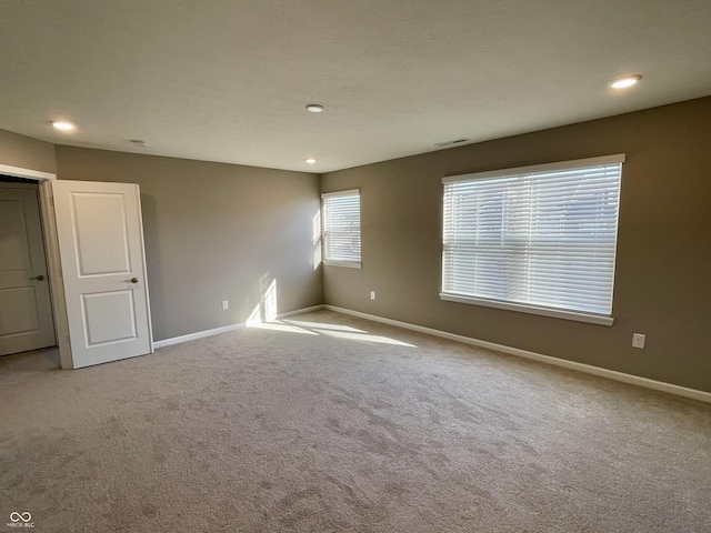 spare room featuring light colored carpet