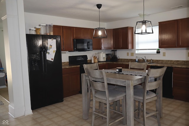 kitchen featuring sink, black appliances, and decorative light fixtures