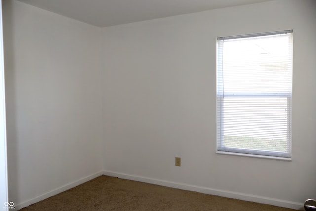 unfurnished room featuring dark carpet