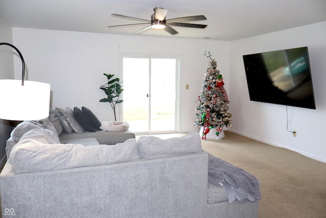 carpeted living room with ceiling fan